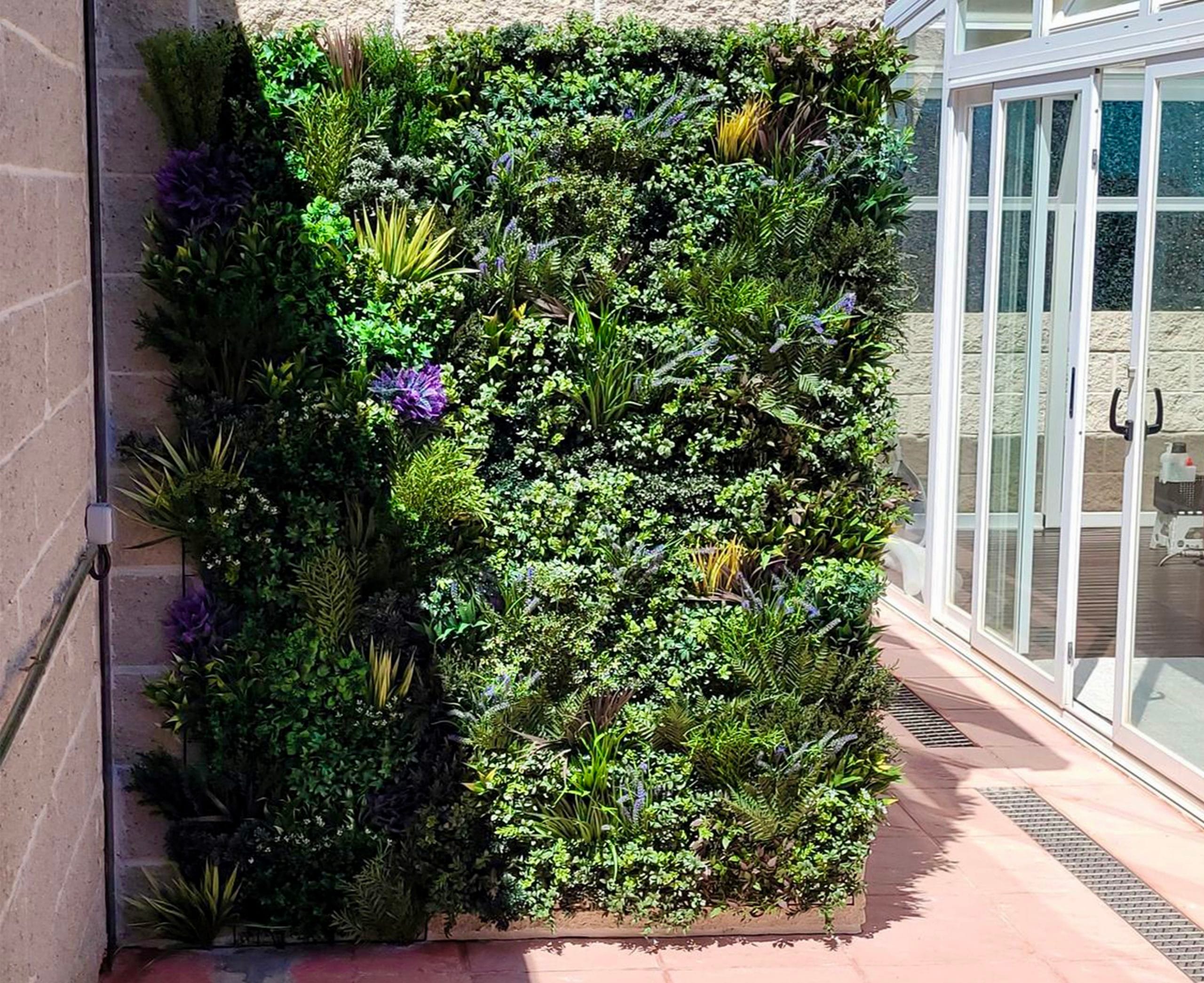 Patio de un un Comercio decorado con un Frondoso y Realista Jardín Vertical.